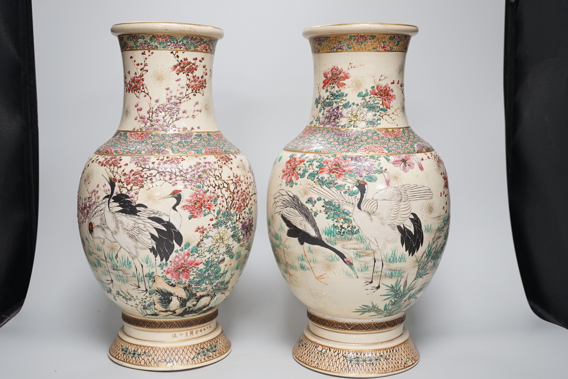 A pair of Japanese Satsuma pottery vases, Meiji period signed above foot, height 38cm